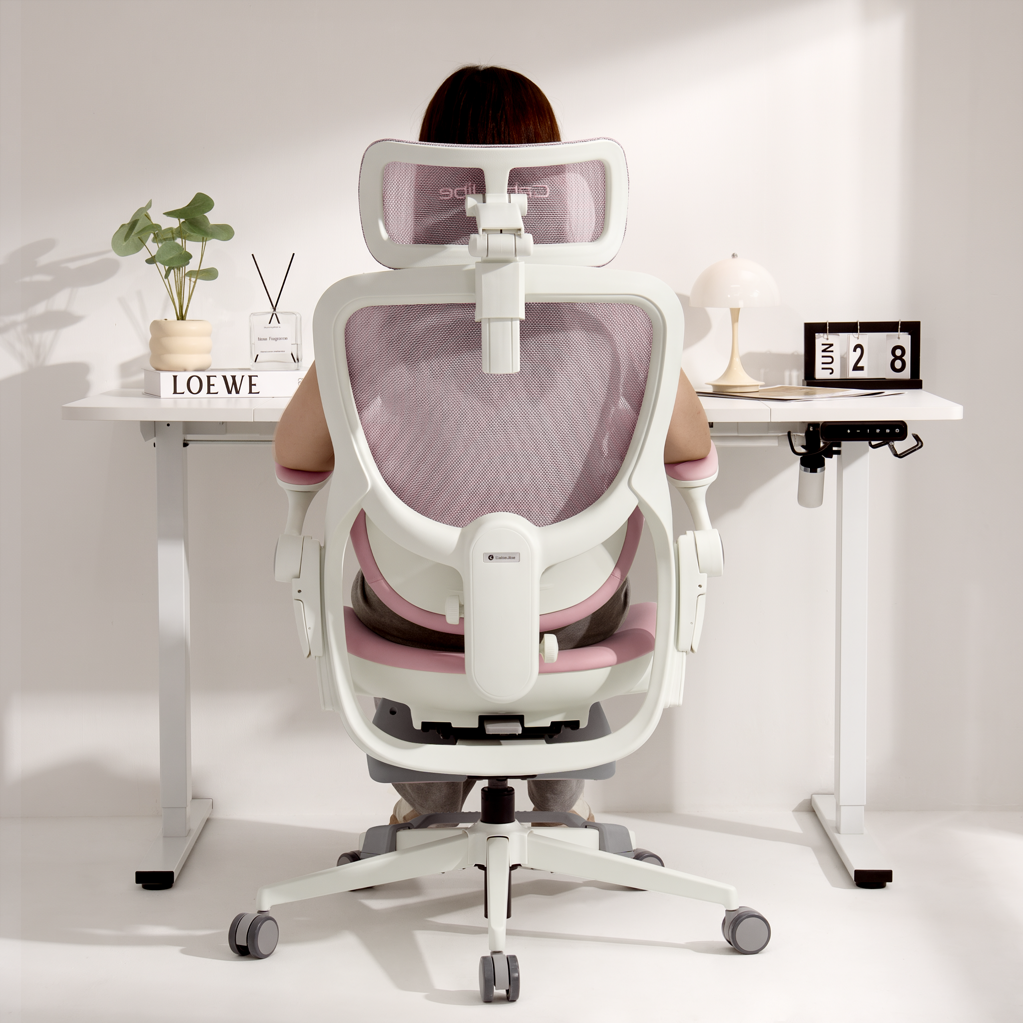 Rear view of a user sitting in the CabeVibe S2 ergonomic office chair at a home office desk