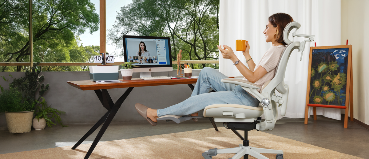 A woman reclines comfortably at 120 degrees in the CabeVibe S2 chair, using the integrated footrest. She holds a coffee mug, looking relaxed while generating ideas during a creative brainstorming session in her home office.